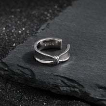 Girl fashion knot 925 sterling silver non-pierced earring on slate background.